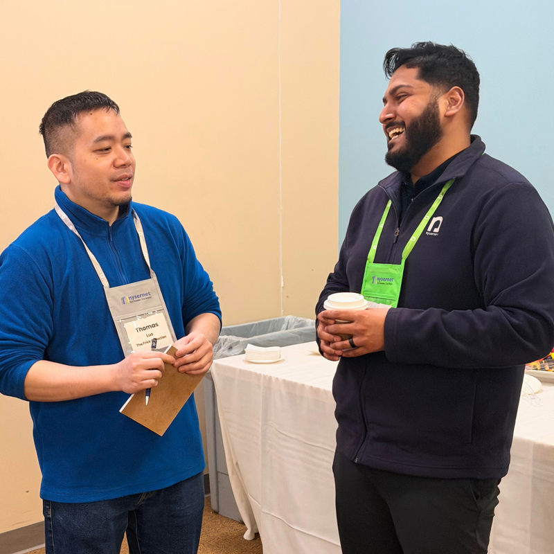 Nysernet Membership Manager Moey Hoque laughs over coffee with a Nysernet member.