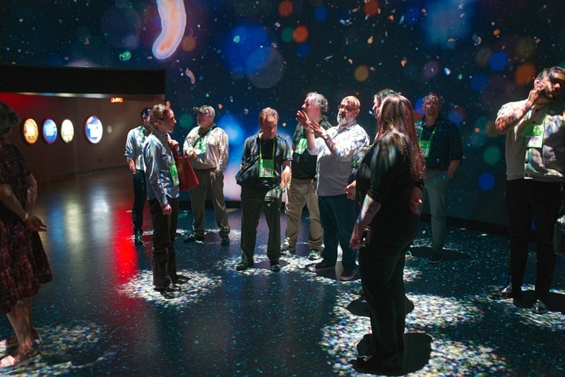 Nysernet members gather in the "Invisible Worlds" exhibit at the American Museum of Natural History