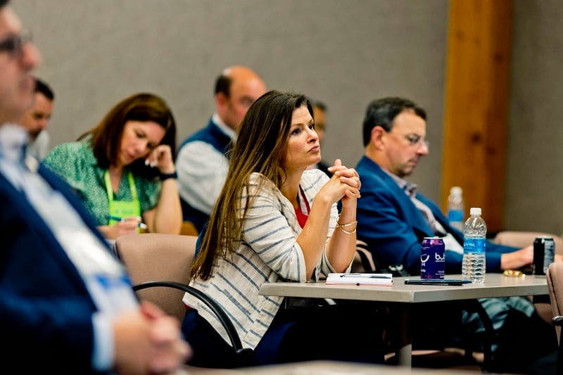 Nysernet member looking pensive, seated at a desk in a room full of colleagues