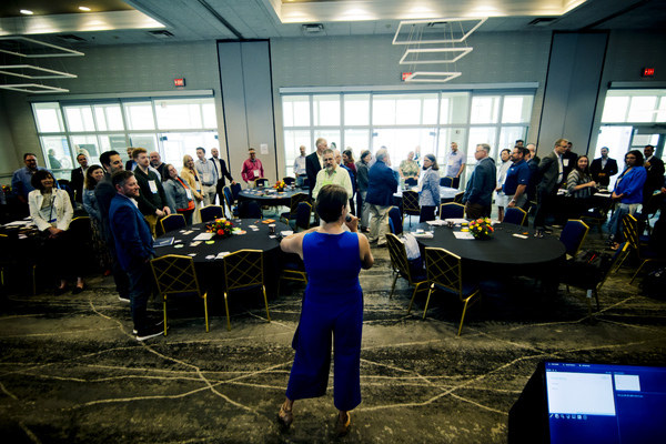 Caitlin Drago has back to camera, leading a conference in an improv activity