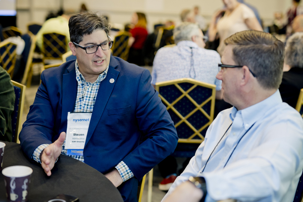 Two people converse at a conference table